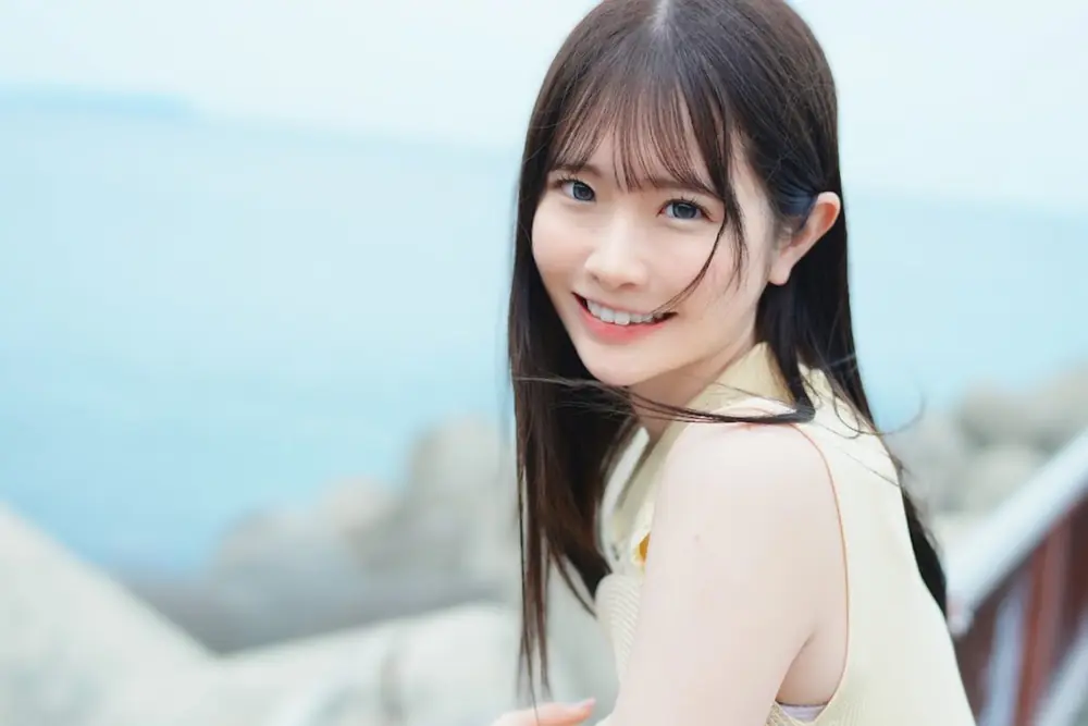 Emika Shirakami ยิ้มให้กล้องในเสื้อแขนกุดสีอ่อน