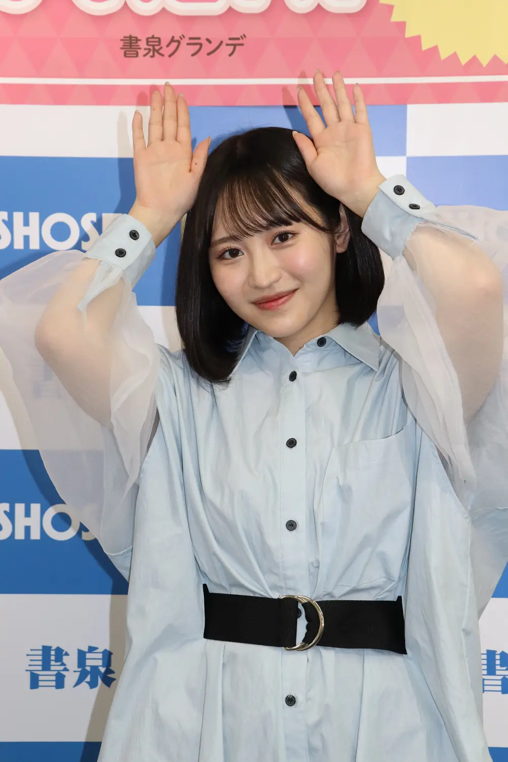 Rikka Ono สวมชุดสีฟ้าอ่อนและยกมือข้างศีรษะ