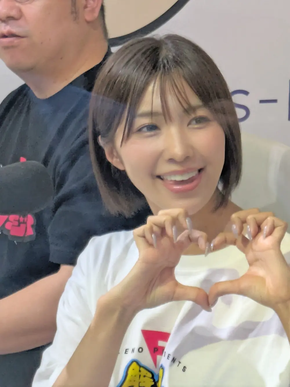 Mai Tsubasa สวมเสื้อสีขาวและทำมือรูปหัวใจ