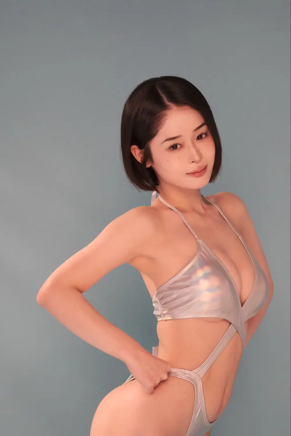 Minamo สวมชุดว่ายน้ำสีเงินและโพสท่าหน้าฉากสีเทา
