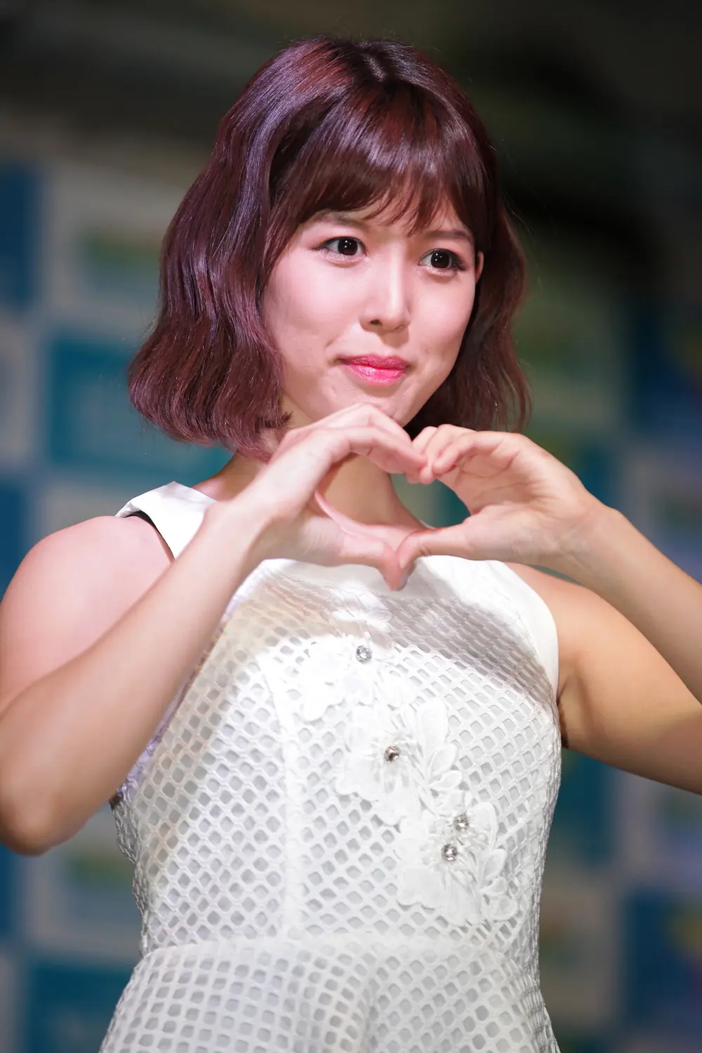 Tsukasa Aoi สวมชุดสีขาวและทำมือเป็นรูปหัวใจ