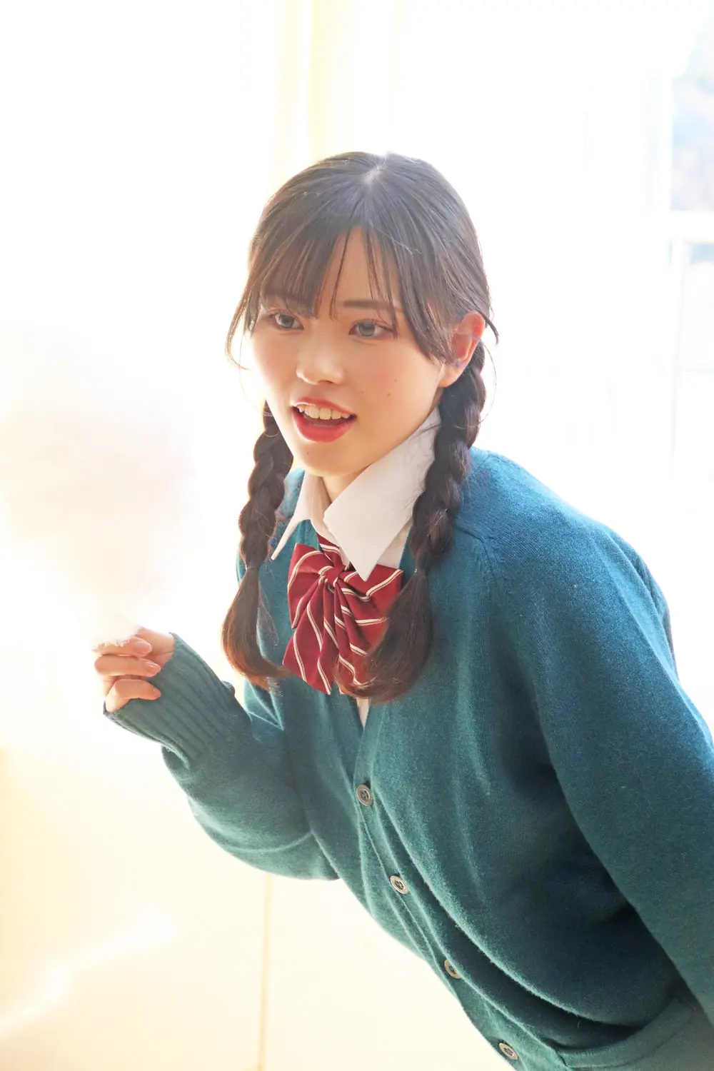 Mia Koki ถักผมเปียและสวมคาร์ดิแกนสีเขียวในงานถ่ายภาพ