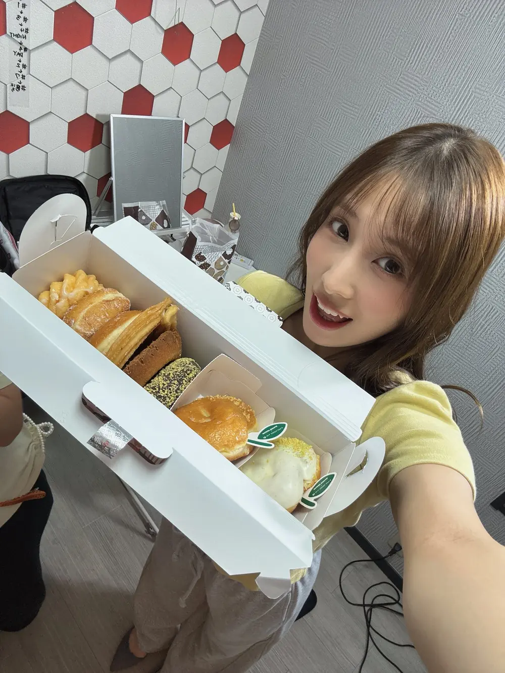 Nene Misumi สวมเสื้อสีเหลืองถือกล่องขนม