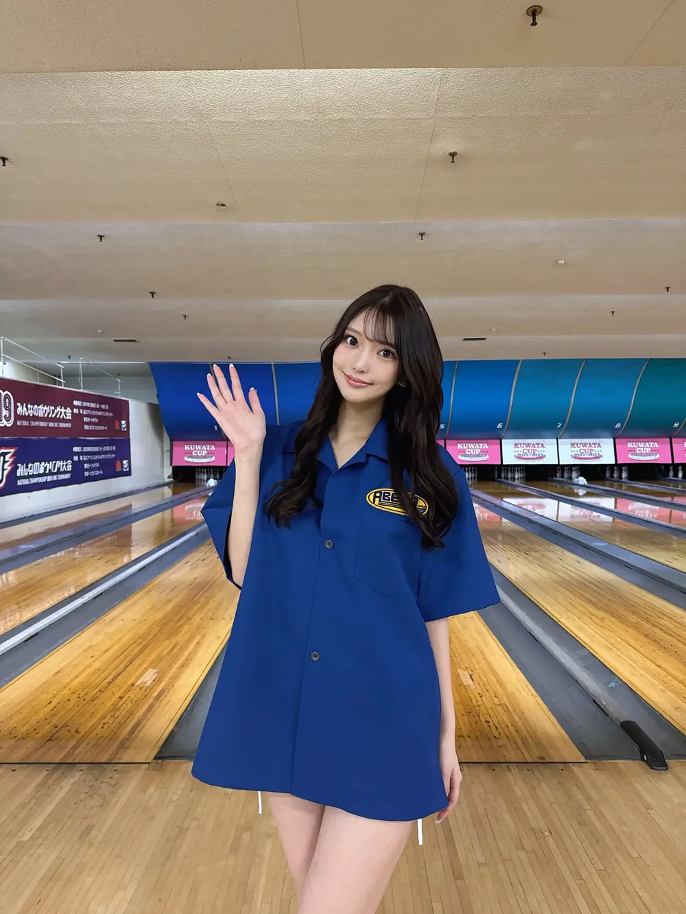 Hana Kuraki สวมเสื้อสีน้ำเงินและยืนโบกมือในลานโบว์ลิง