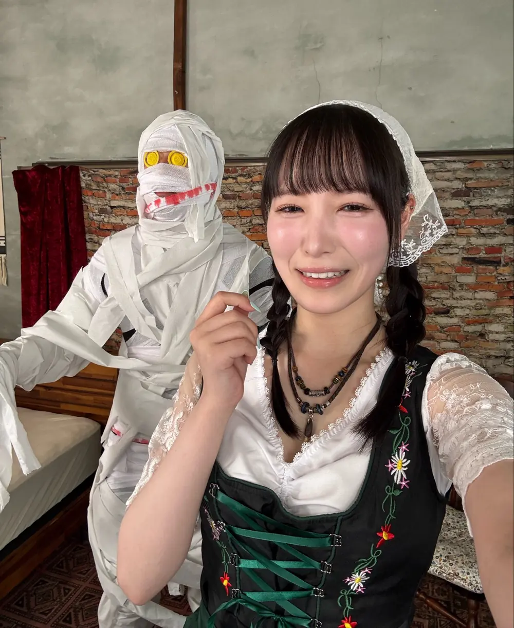 Jun Kasui สวมชุดสีเขียวกับเสื้อลูกไม้สีขาวและถักผมเปีย