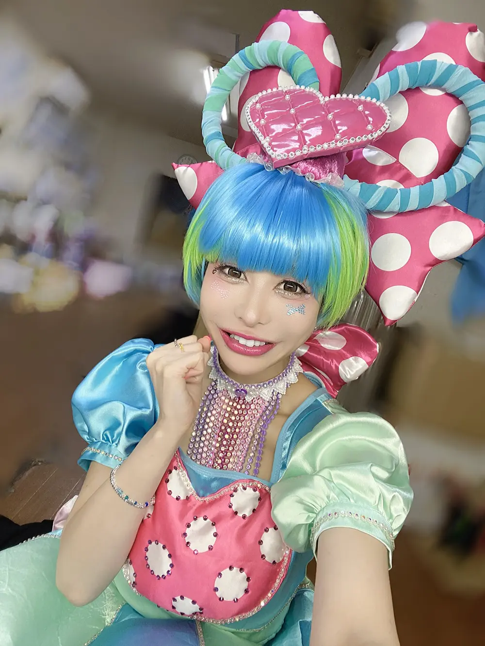 Maaya Irita สวมชุดคอสเพลย์สีฟ้าและชมพูบนเวที