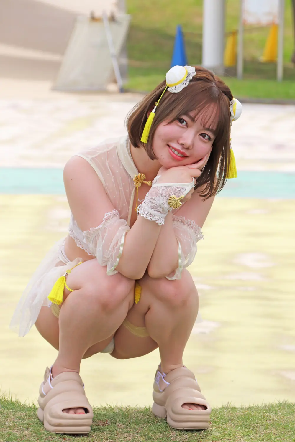 Misao Oguri สวมชุดว่ายน้ำสีอ่อนและโพสท่าที่สวนน้ำ
