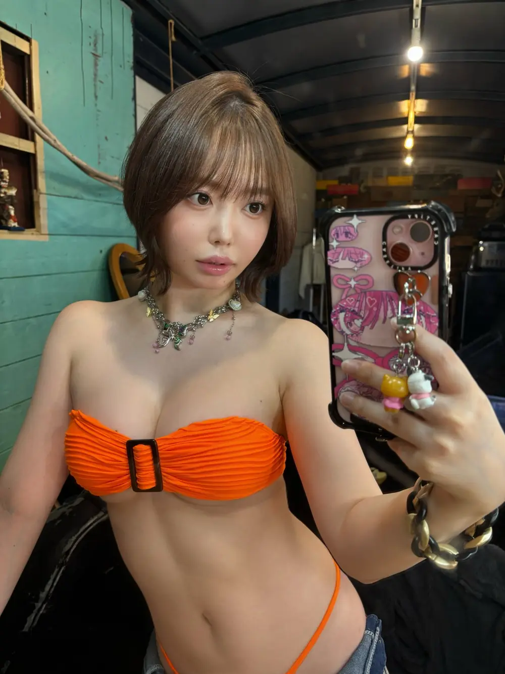 Misao Oguri สวมชุดว่ายน้ำสีส้มและถ่ายภาพหน้ากระจก