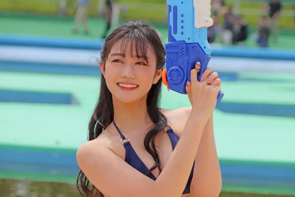 Mitsuha Ashitaba สวมชุดว่ายน้ำสีน้ำเงินและถือปืนฉีดน้ำ