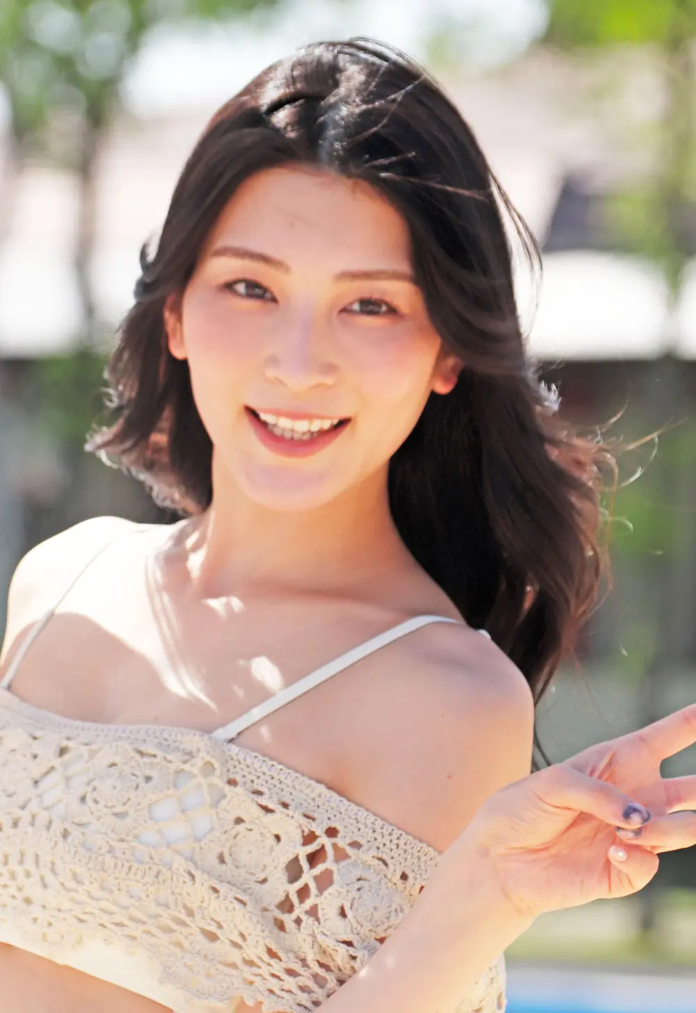Suzu Honjo สวมเสื้อคลุมลายถักสีอ่อนและยิ้มกลางแจ้ง