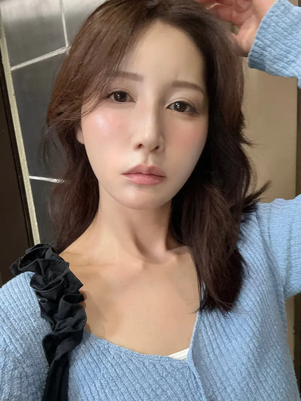 Aki Sasaki ในเสื้อถักสีฟ้าจากภาพเซลฟีในบัญชี X ทางการ