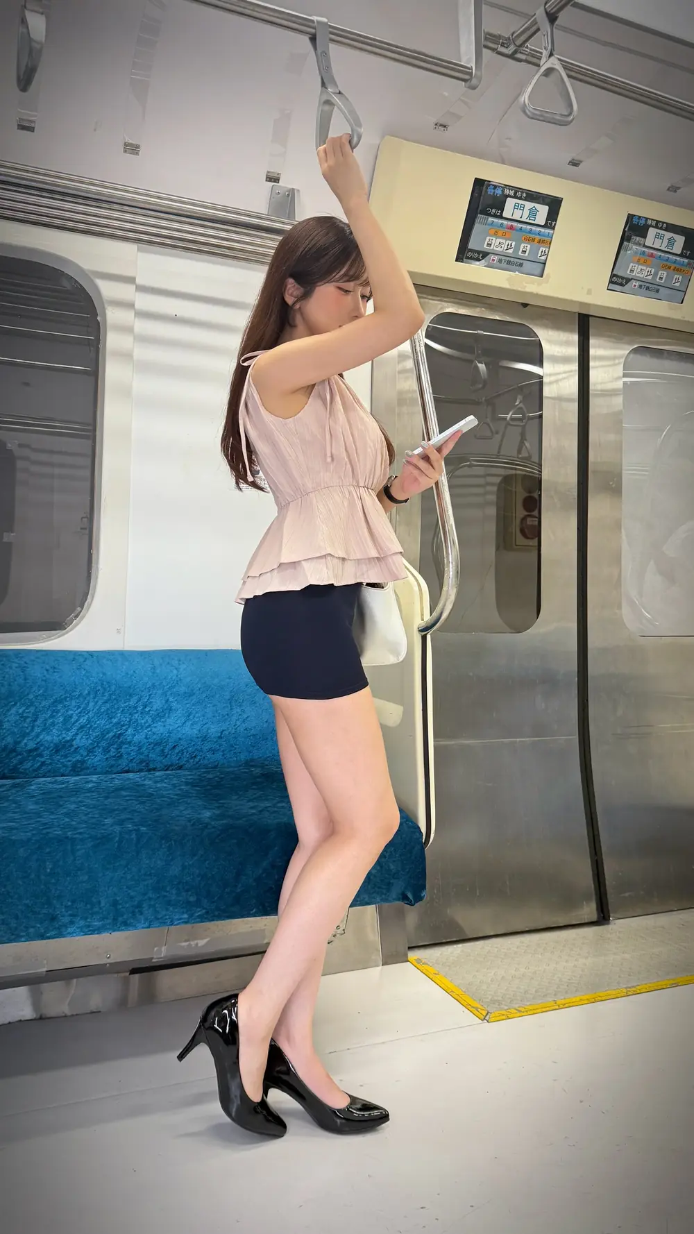Hibiki Otsuki สวมเสื้อสีชมพูและกางเกงขาสั้นในตู้รถไฟ