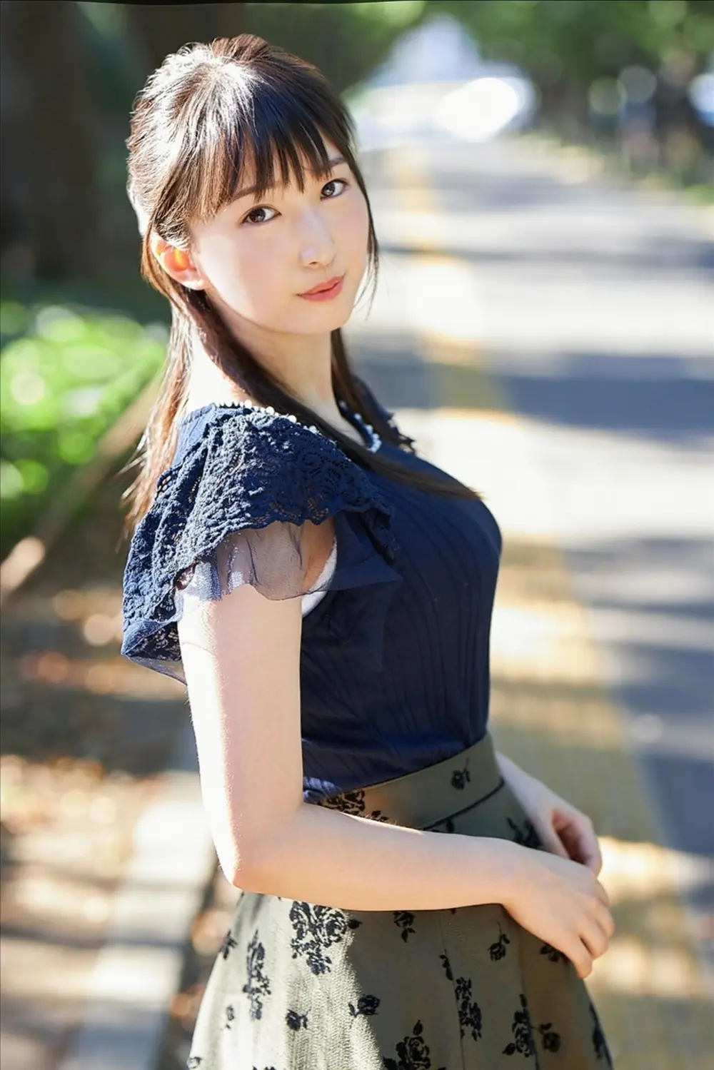 Kasumi Tsukino ยืนถ่ายภาพกลางแจ้งในชุดสีเข้ม