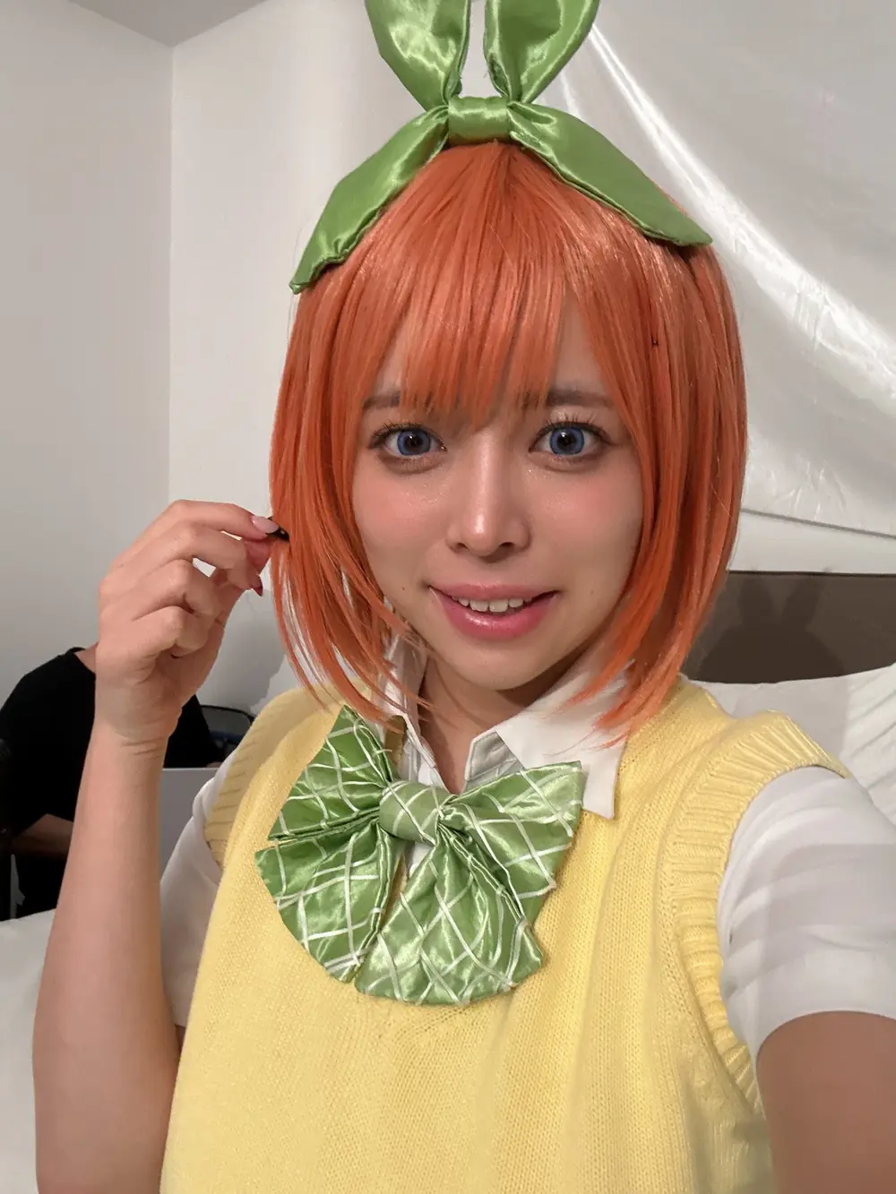 Noa Haruna สวมวิกสีส้ม เสื้อกั๊กสีเหลือง และโบสีเขียว