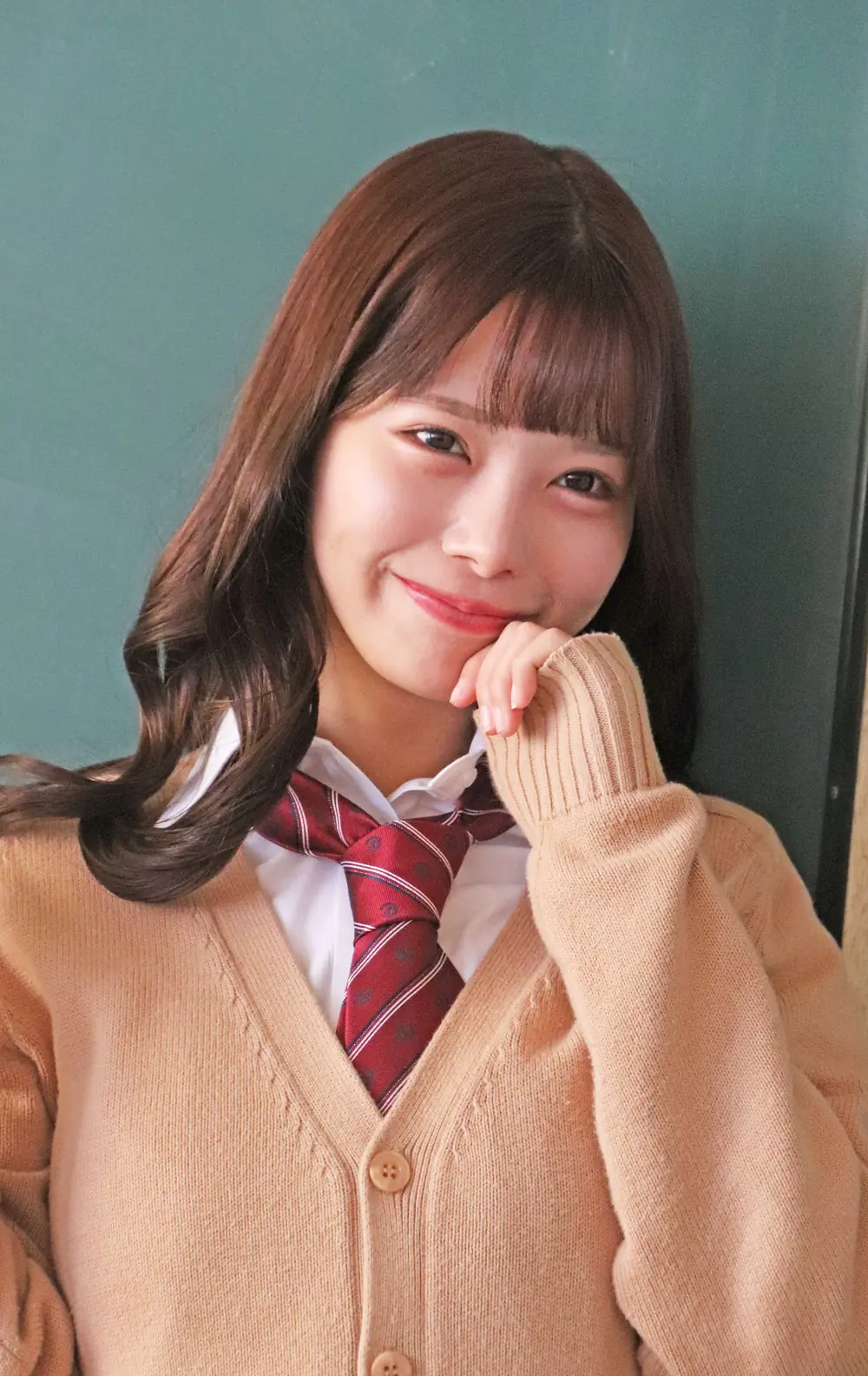 Yua Fukuda สวมคาร์ดิแกนสีน้ำตาลอ่อนและเนกไทสีแดง
