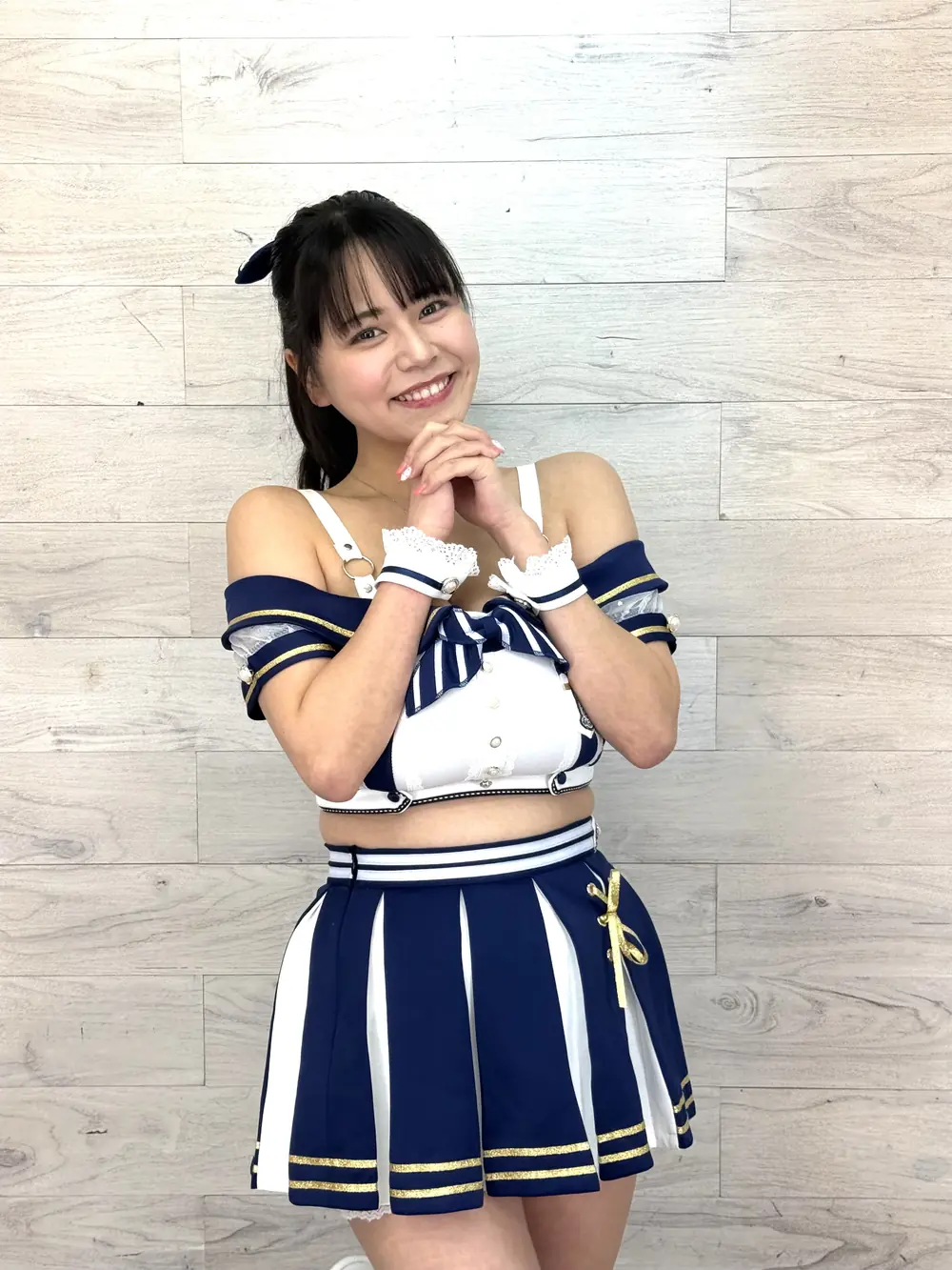 Yu Tano ยิ้มและประสานมือใต้คางในชุดคอสเพลย์สีน้ำเงินขาว