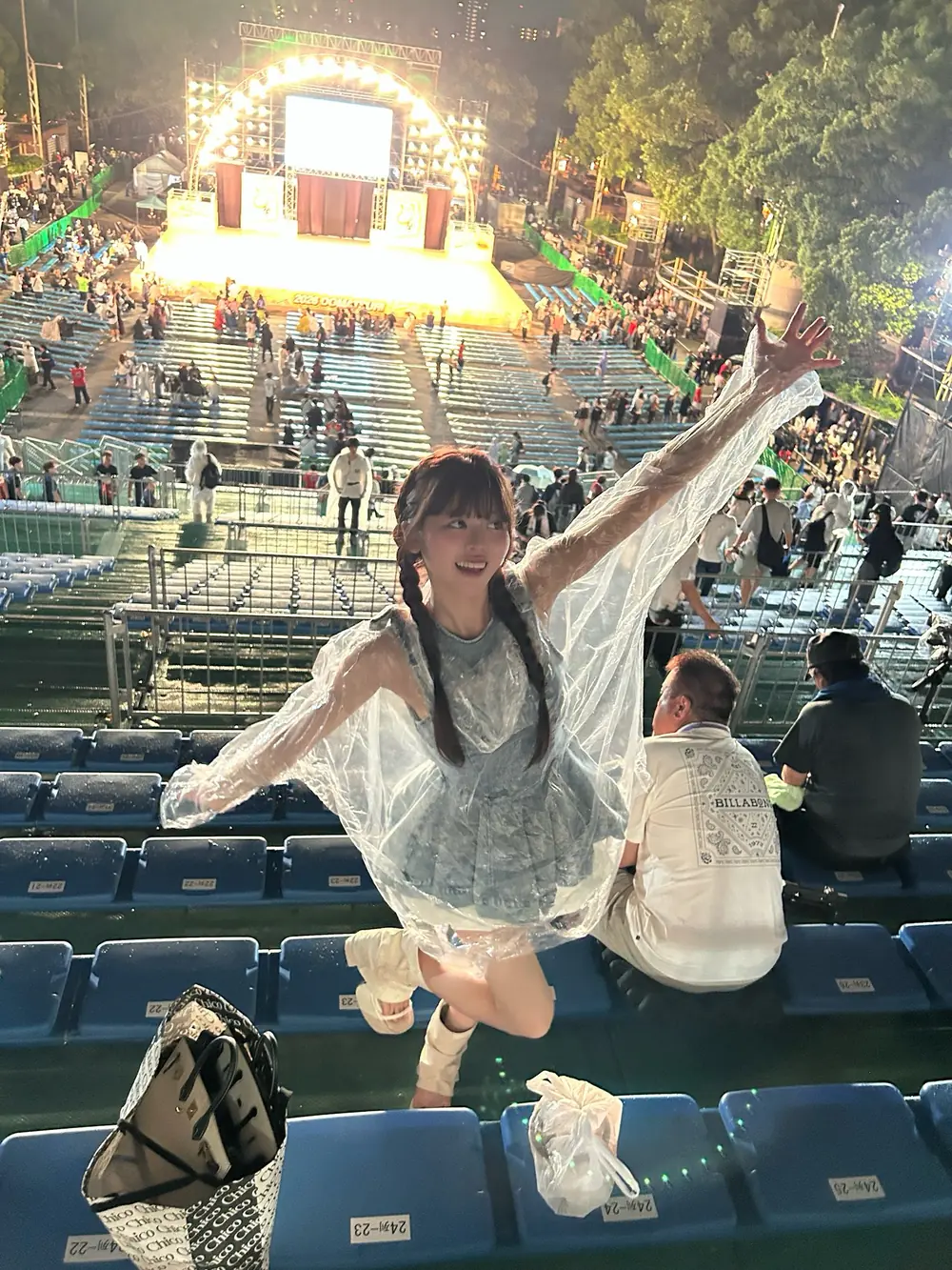 Rino Sakurano ยืนยกแขนเหนือที่นั่งผู้ชมหน้าเวทีงานกลางคืน