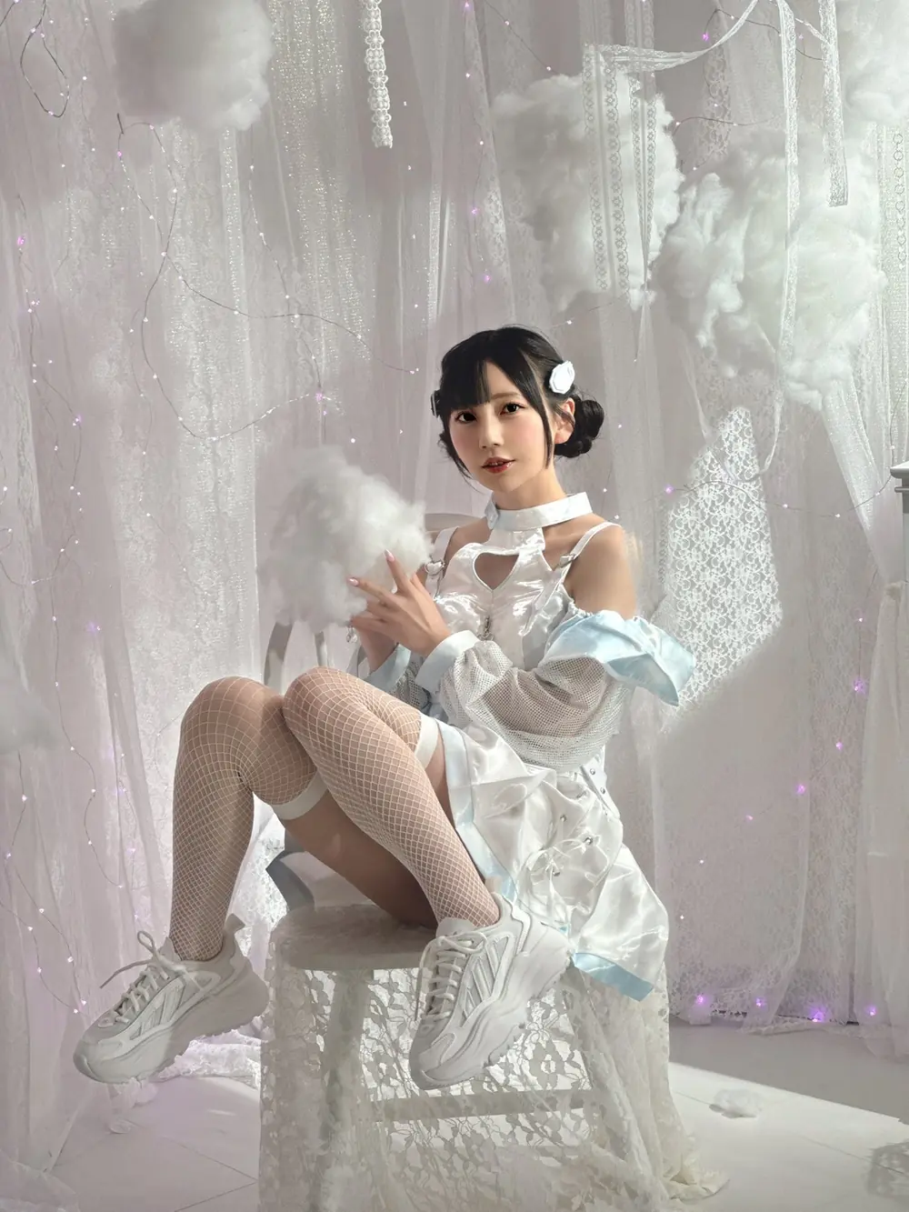 Mia Nanasawa สวมชุดสีขาวและนั่งบนเก้าอี้ในห้องแสงอ่อน