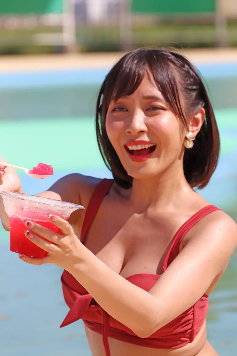ภาพ Rika Aimi ในชุดว่ายน้ำสีแดงถือเครื่องดื่มในงานถ่ายภาพ