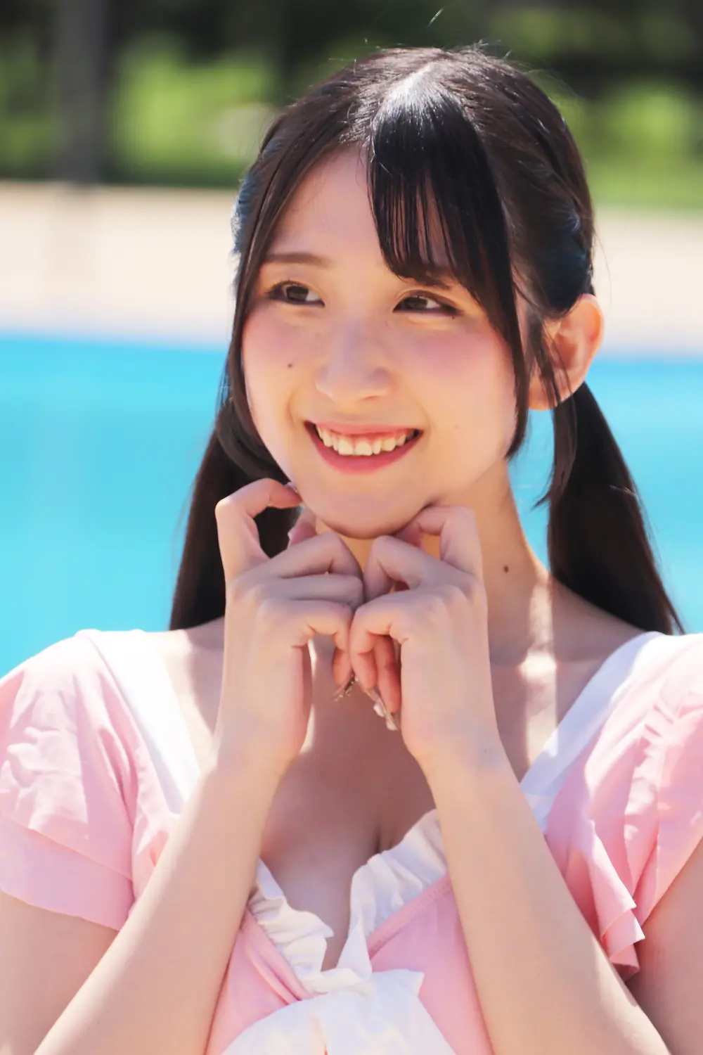Marina Yakuno ยิ้มและวางมือใต้คาง สวมชุดสีชมพูอ่อนขอบขาว