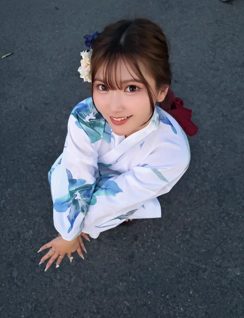Akari Nonoka สวมชุดยูกาตะสีขาวลายดอกไม้สีน้ำเงินและประดับดอกไม้บนผม