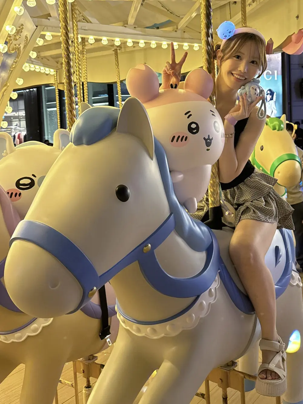 Alice Shaku นั่งบนม้าหมุนตกแต่งด้วยตัวการ์ตูน