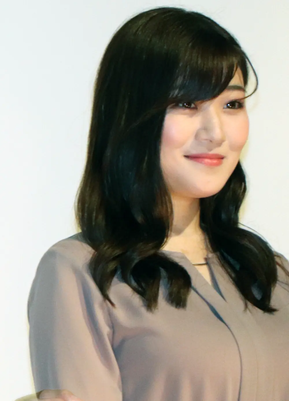 Ena Koume สวมเสื้อสีเทาอ่อนและยิ้มในงานภาพยนตร์