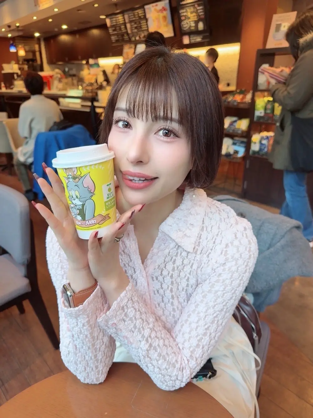 Hazuki Ichinose ถือแก้วเครื่องดื่มถ่ายภาพในร้านกาแฟ