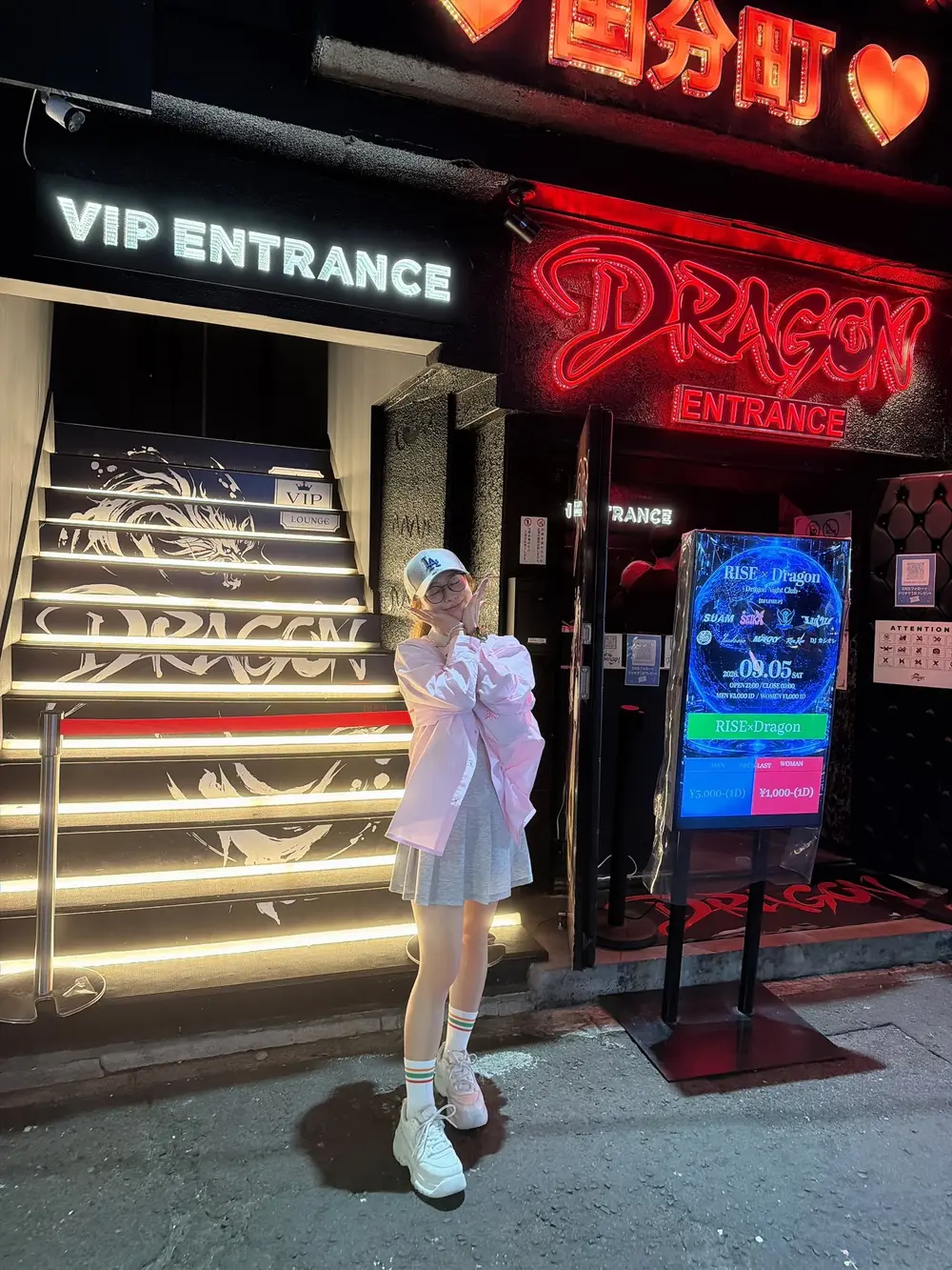 Marina Shiraishi สวมเสื้อคลุมสีขาวยืนหน้าทางเข้า Dragon ในย่านโคคุบุนโจ