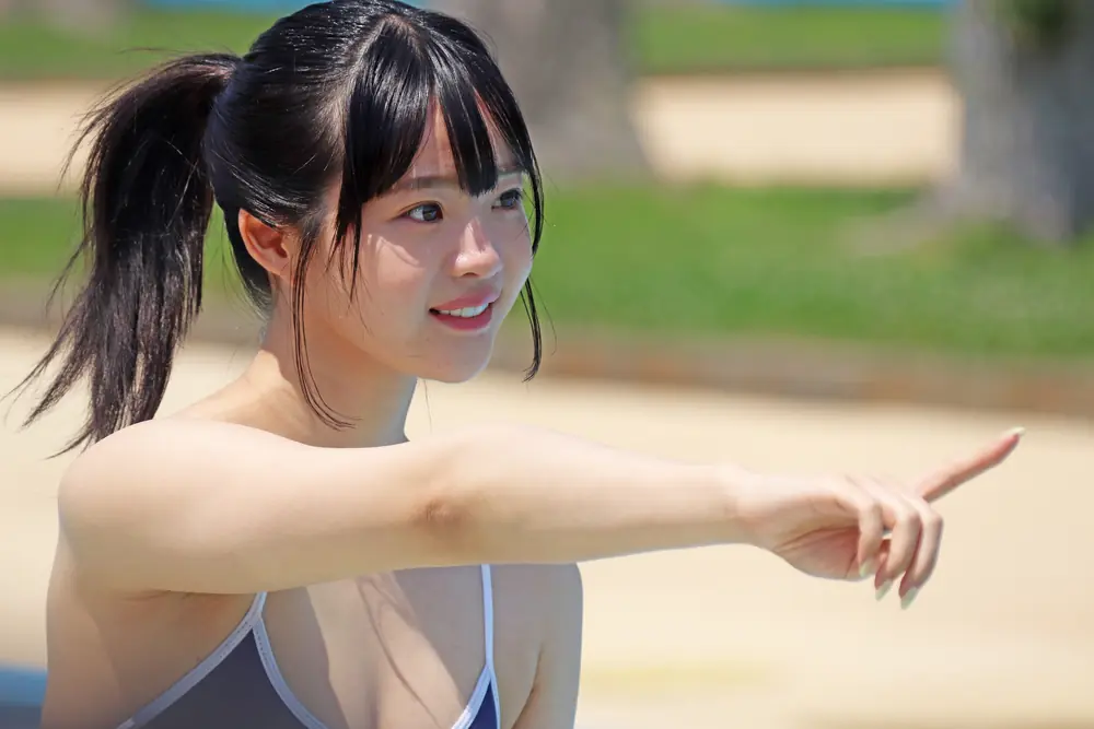 Momo Inoue มัดผมสองข้างและชี้มือออกไปด้านข้าง