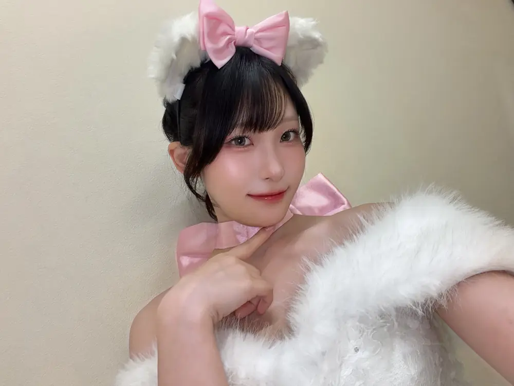 Sora Arakawa สวมชุดสีขาวขอบขนฟูและโบสีชมพูบนผม