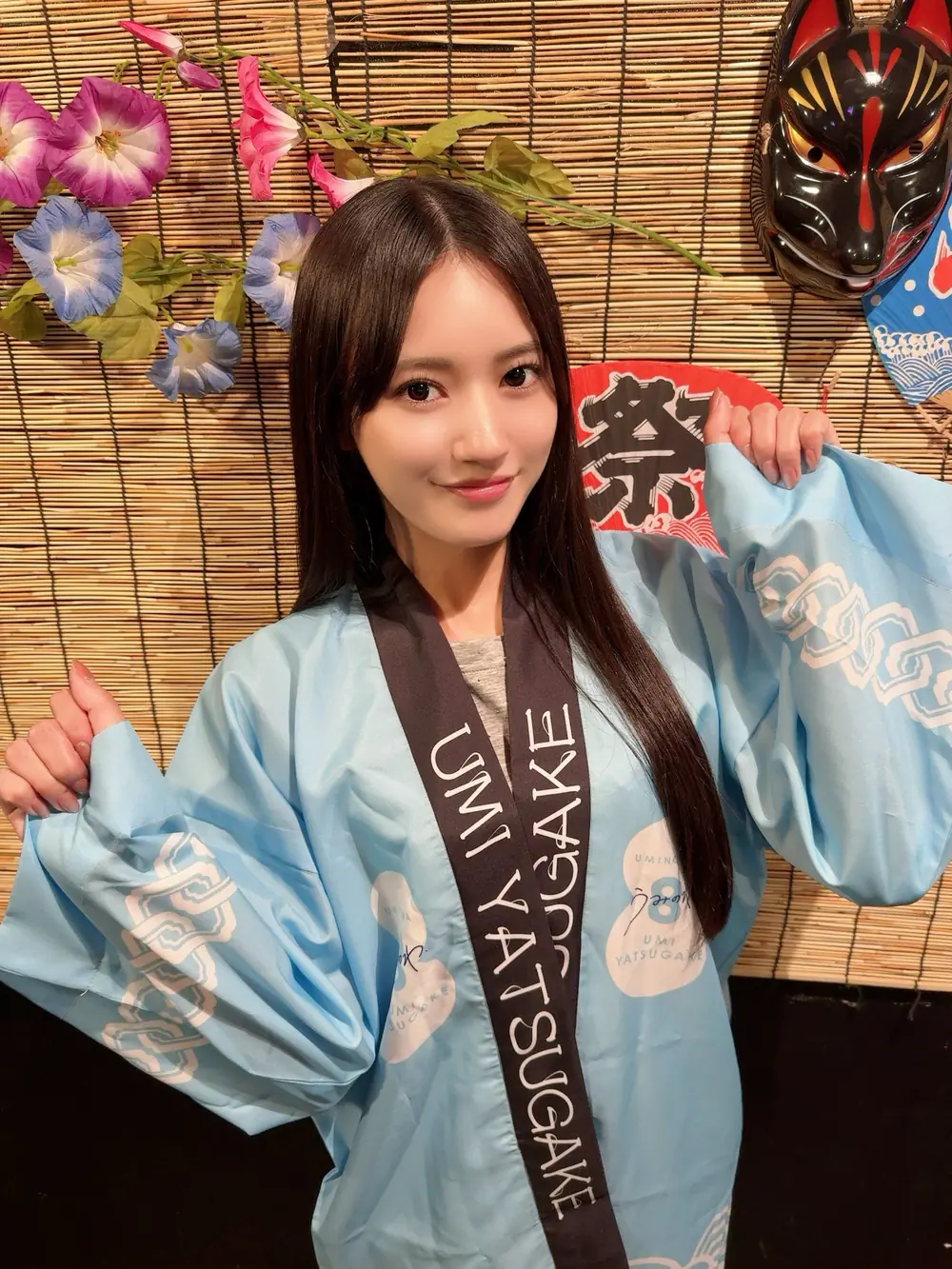 Umi Yatsugake สวมเสื้อฮัปปิสีฟ้าหน้าฉากงานเทศกาล