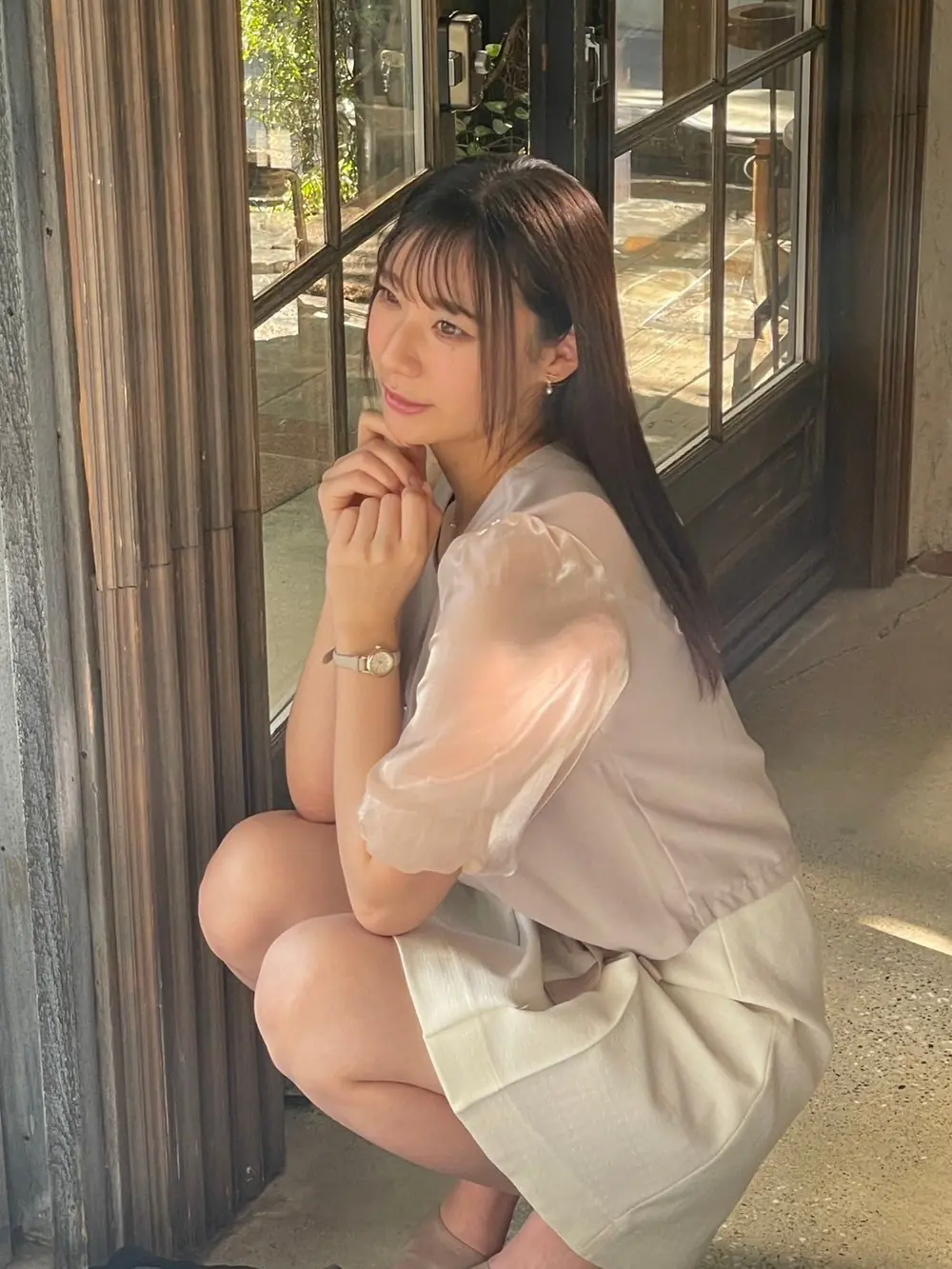 Yuka Miyoshi นั่งถ่ายภาพในชุดสีอ่อนบริเวณหน้าต่าง