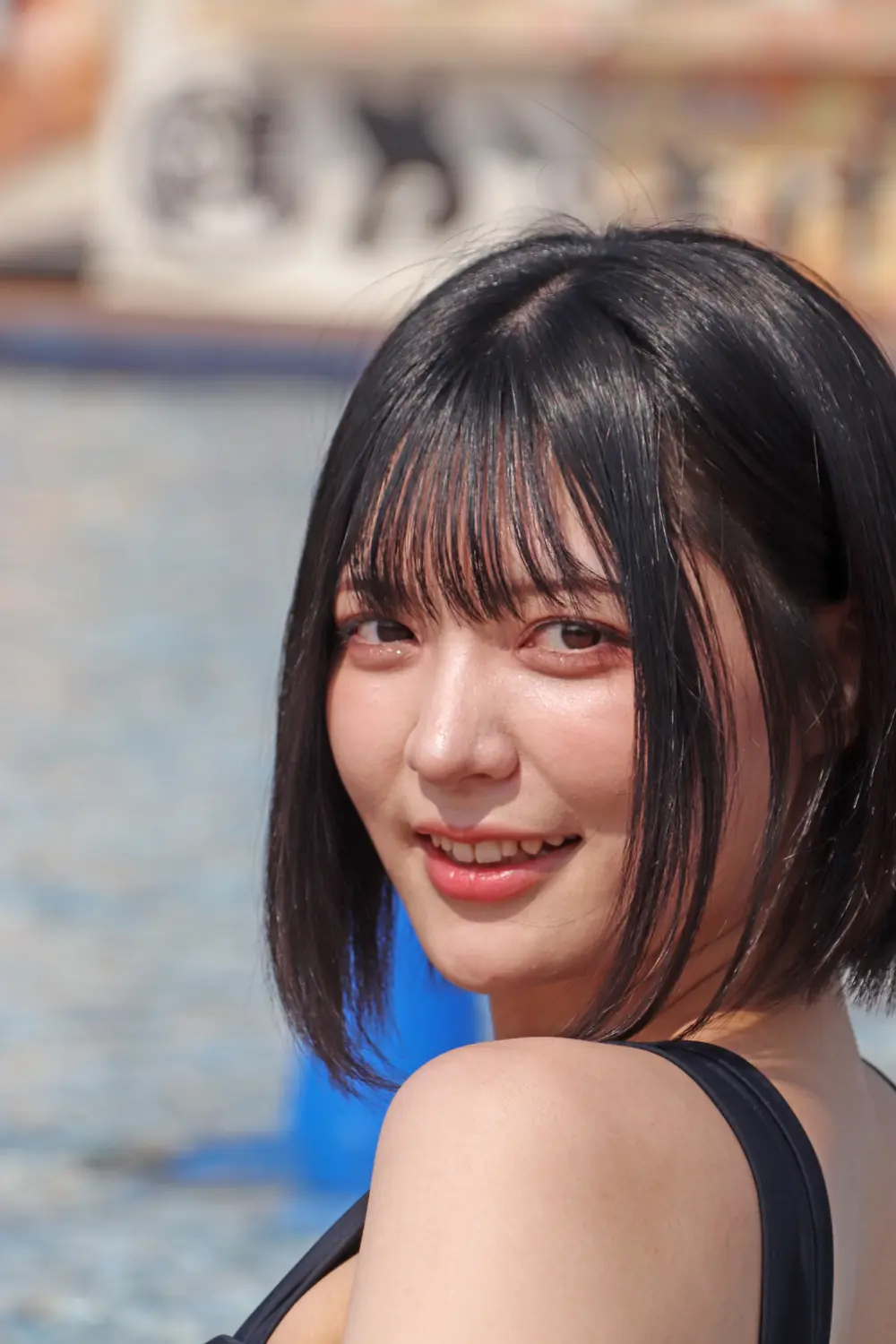 Yumi Nijimura สวมเสื้อสีดำและหันมายิ้ม