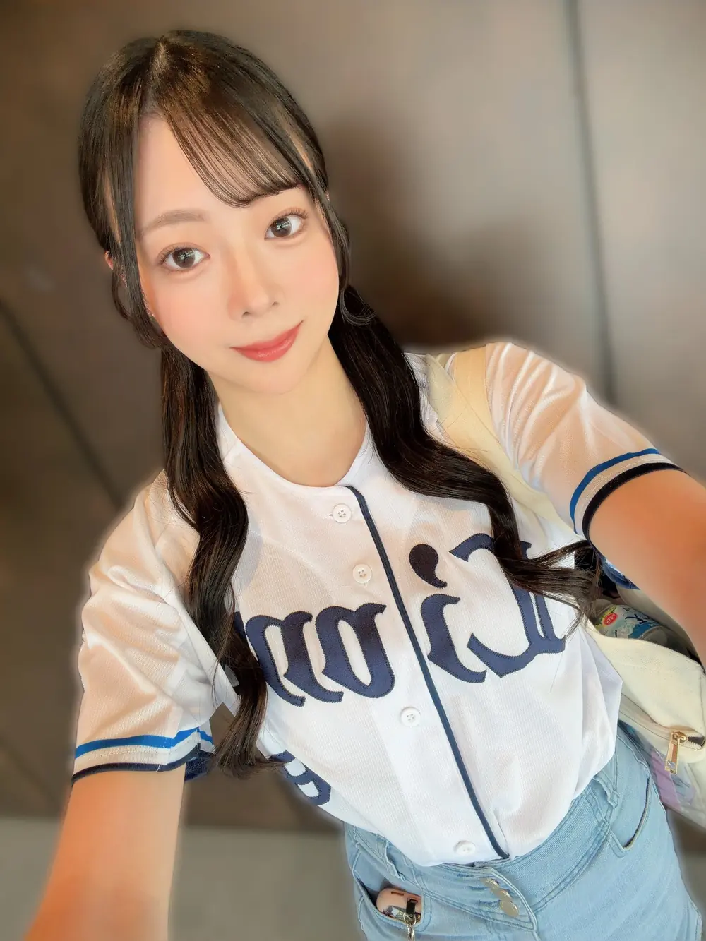 Rui Shinomiya สวมเสื้อเบสบอลสีขาวระหว่างติดตามการแข่งขัน