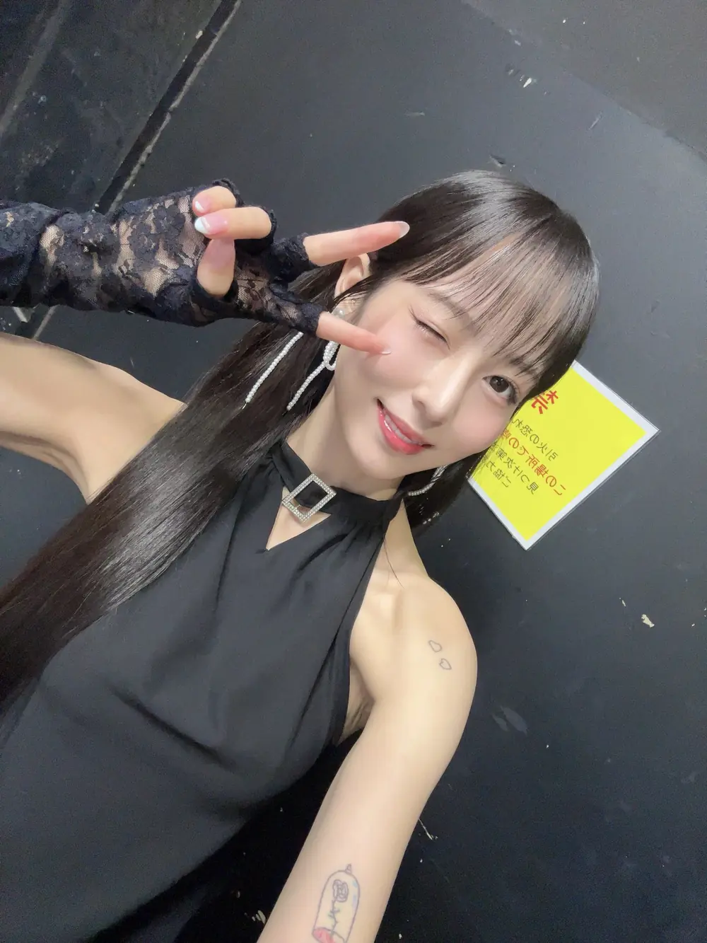 Hana Honjo ถ่ายภาพเซลฟี่ในชุดสีดำหลังเวที