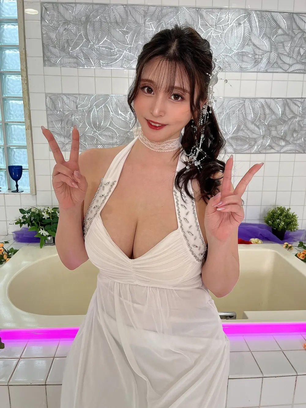 Mika Azuma สวมเดรสสีขาวประดับประกายและชูสองนิ้วทั้งสองมือ