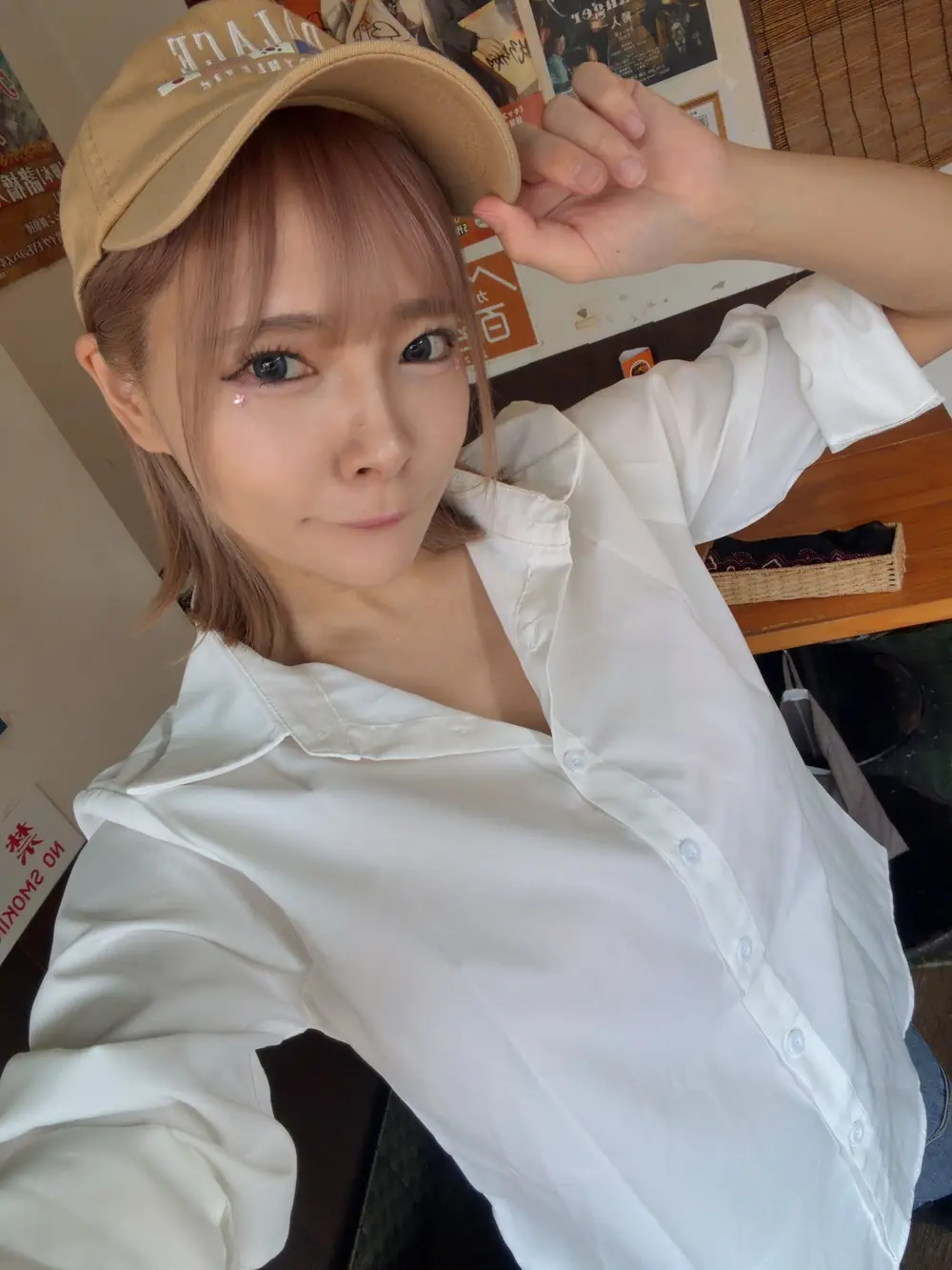 Mio Ichijo สวมเสื้อเชิ้ตสีขาวและหมวกแก๊ปในโพสต์ประกาศกิจกรรมร้าน Soup Curry Kamui