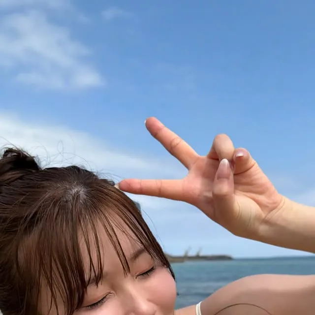 Miu Mirai ยิ้มท่ามกลางท้องฟ้าและทะเลในภาพถ่ายริมชายหาด