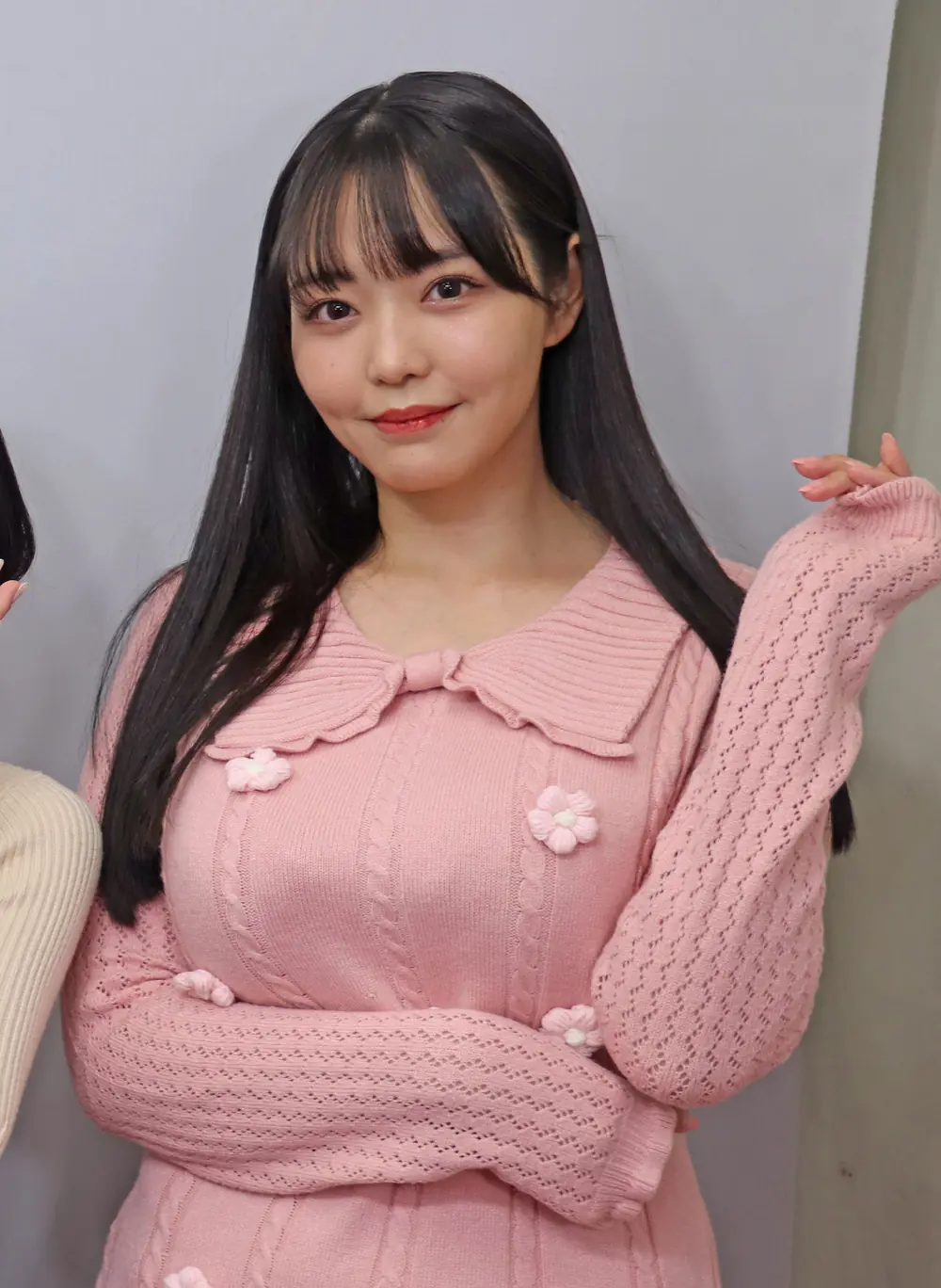 Momona Koibuchi สวมเสื้อถักสีชมพูประดับดอกไม้และปล่อยผมยาว
