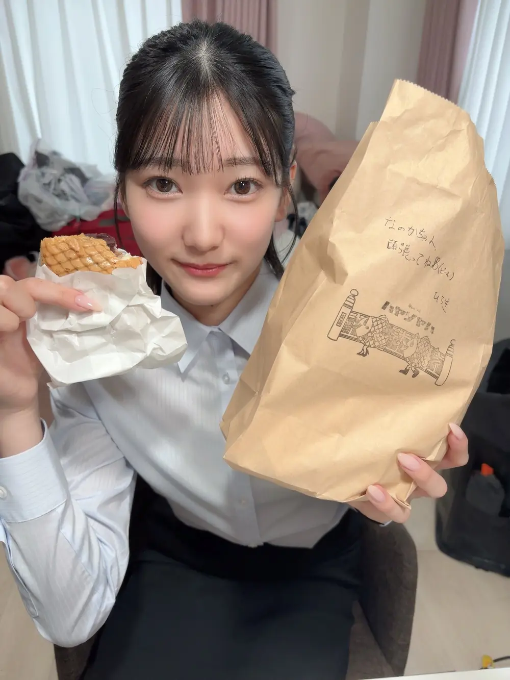 Nanoka Hatsumi ถือขนมและถุงกระดาษในภาพไลฟ์สไตล์