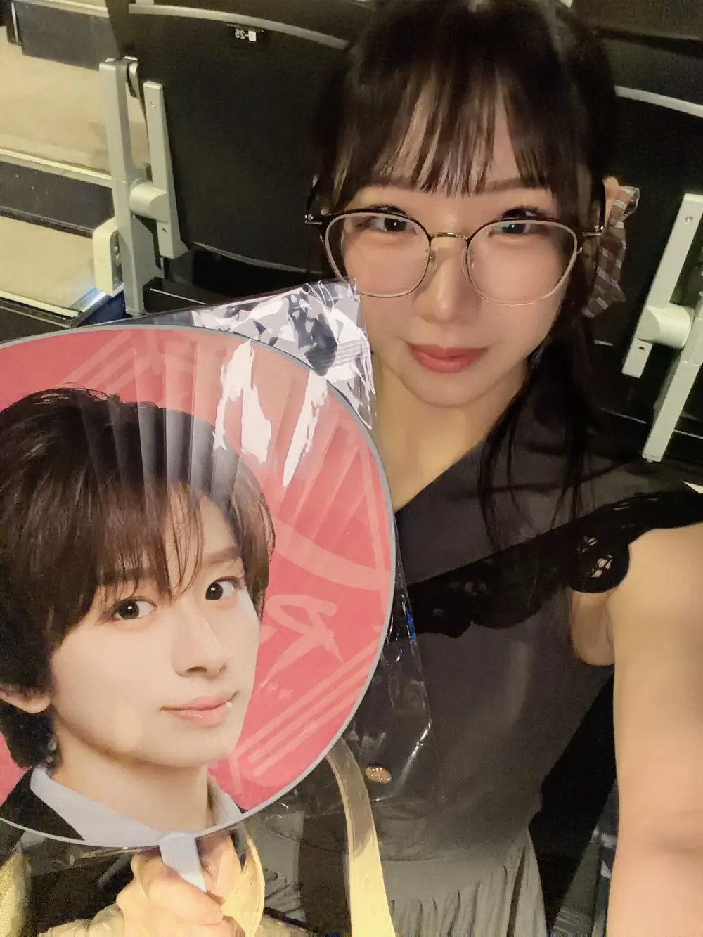Natsuki Mizukawa สวมแว่นและถือพัดรูปศิลปินขณะไปชมคอนเสิร์ต
