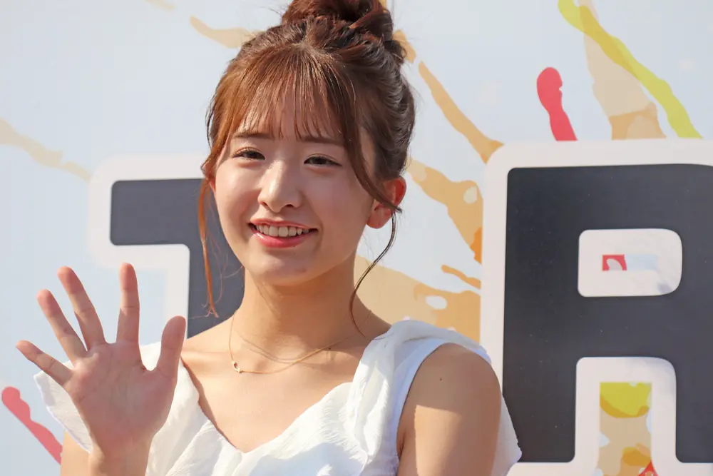 Sakura Kawaguchi เกล้าผม สวมชุดสีขาวและโบกมือ