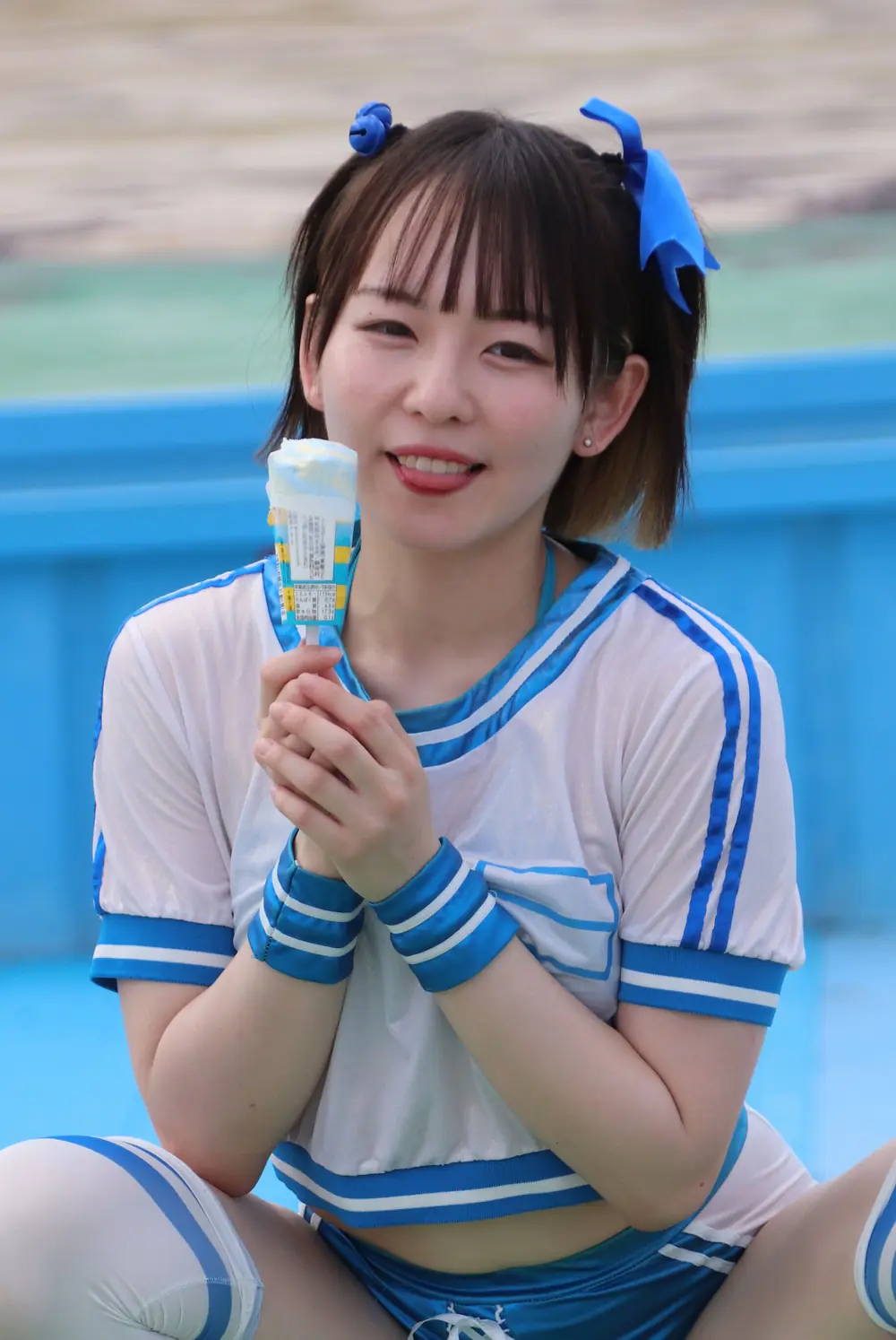 Nishimoto Meisa สวมชุดสีฟ้าและขาวถือไอศกรีมริมสระ