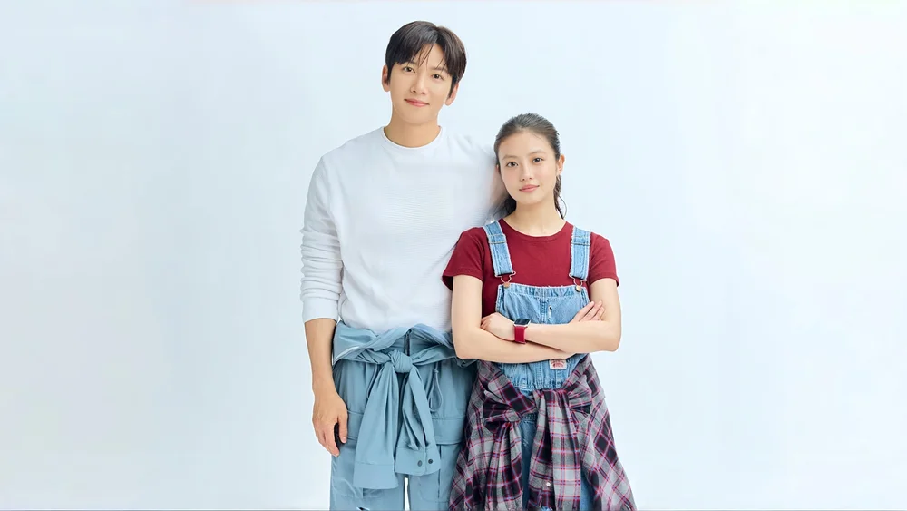 นักแสดงนำชายหญิงในชุดลำลองยืนคู่กันในภาพโปรโมต