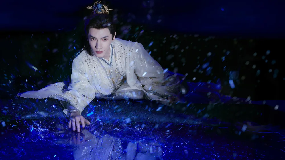 ภาพนักแสดงชายในชุดขาวท่ามกลางละอองน้ำสีฟ้า